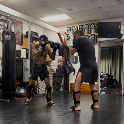 Two fighters sparring while both are wearing Kickin' Combat "Origins" high cut gladiator MMA shorts