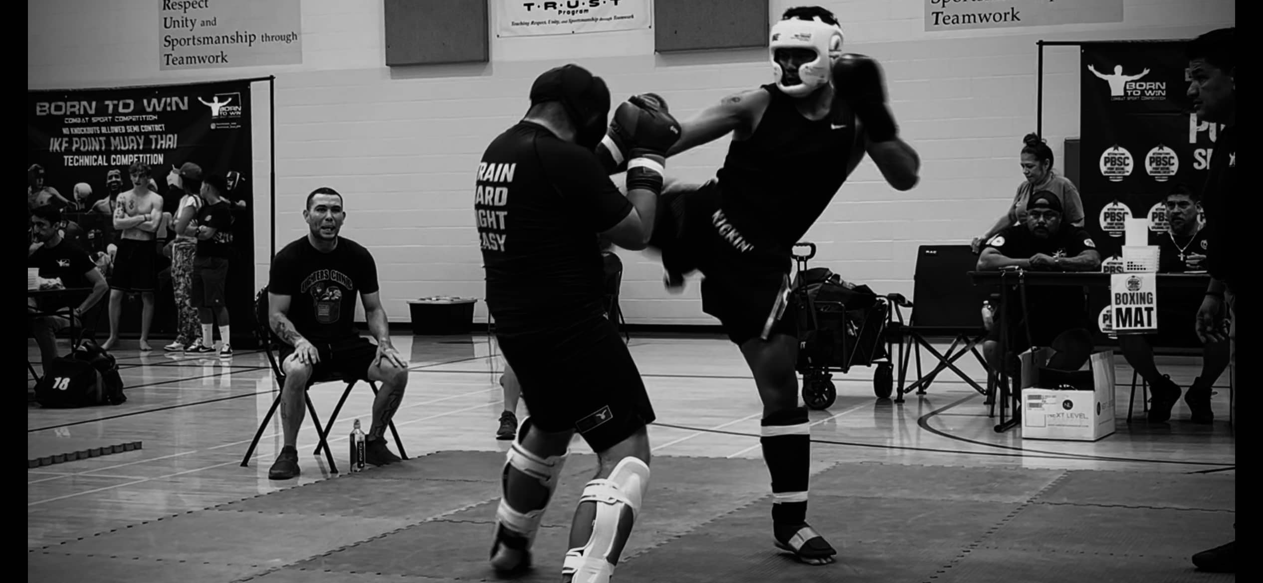 Kickin' Combat high cut gladiator MMA shorts being worn in competition black and white homepage banner